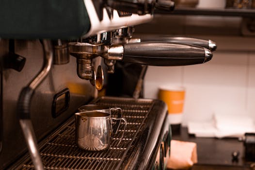 Detailed view of an espresso machine pouring coffee into cups, capturing the coffee-making process.