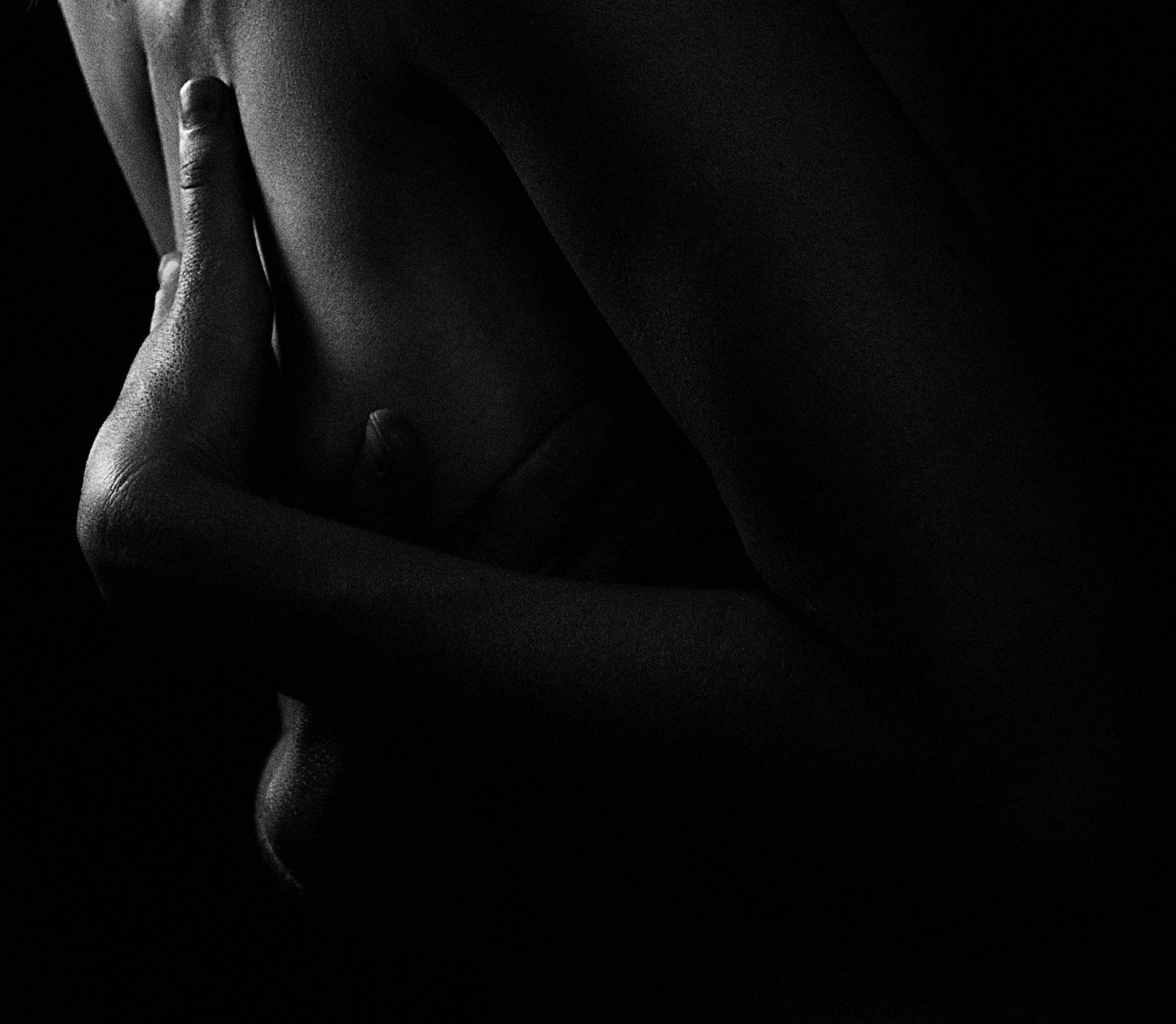 Close-up artistic hands gently touching bare skin in soft shadows, conveying tender hypnotic connection