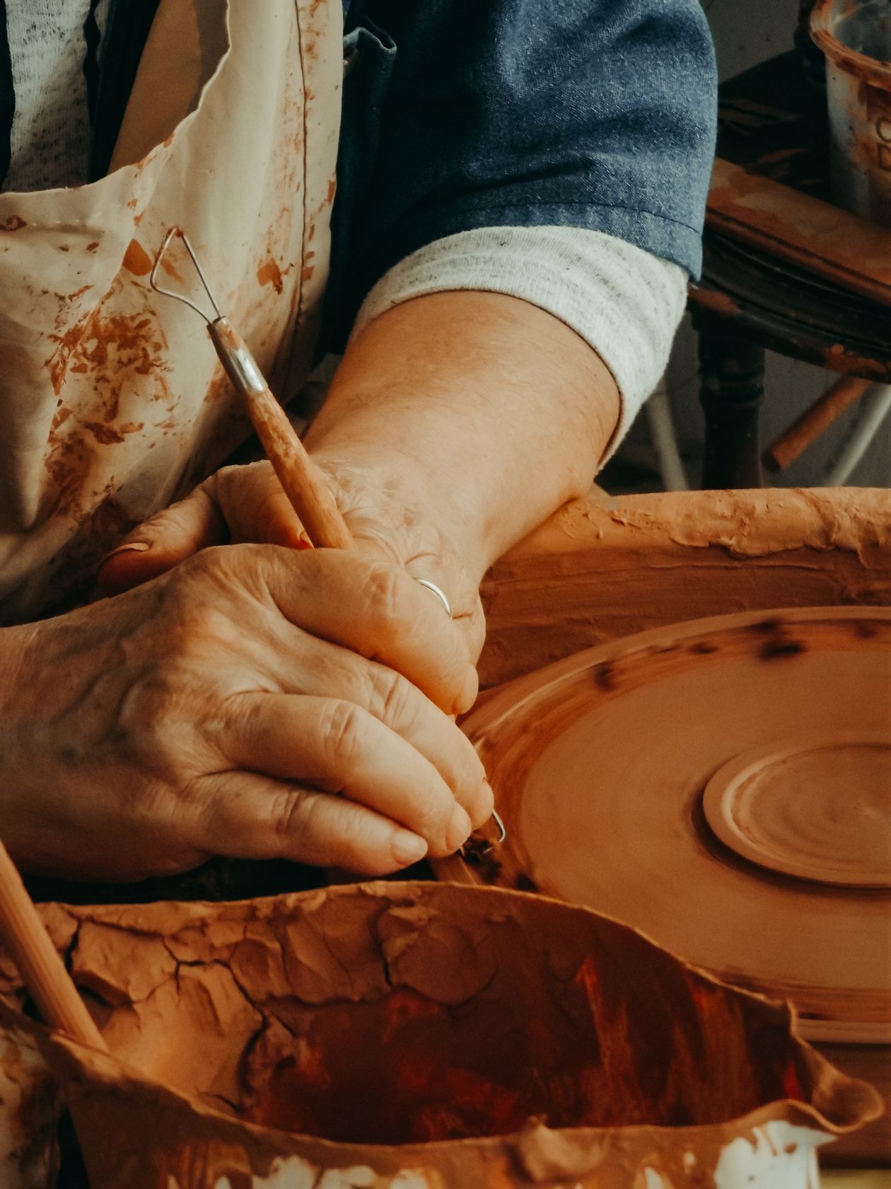 Woman sculpting a form from a block of clay