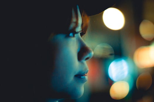 A captivating side profile of a young person at night in Hong Kong with urban lights creating a bokeh effect.
