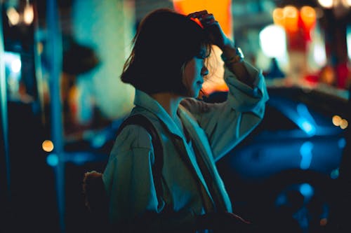 Young Woman in White Coat in the City at Night