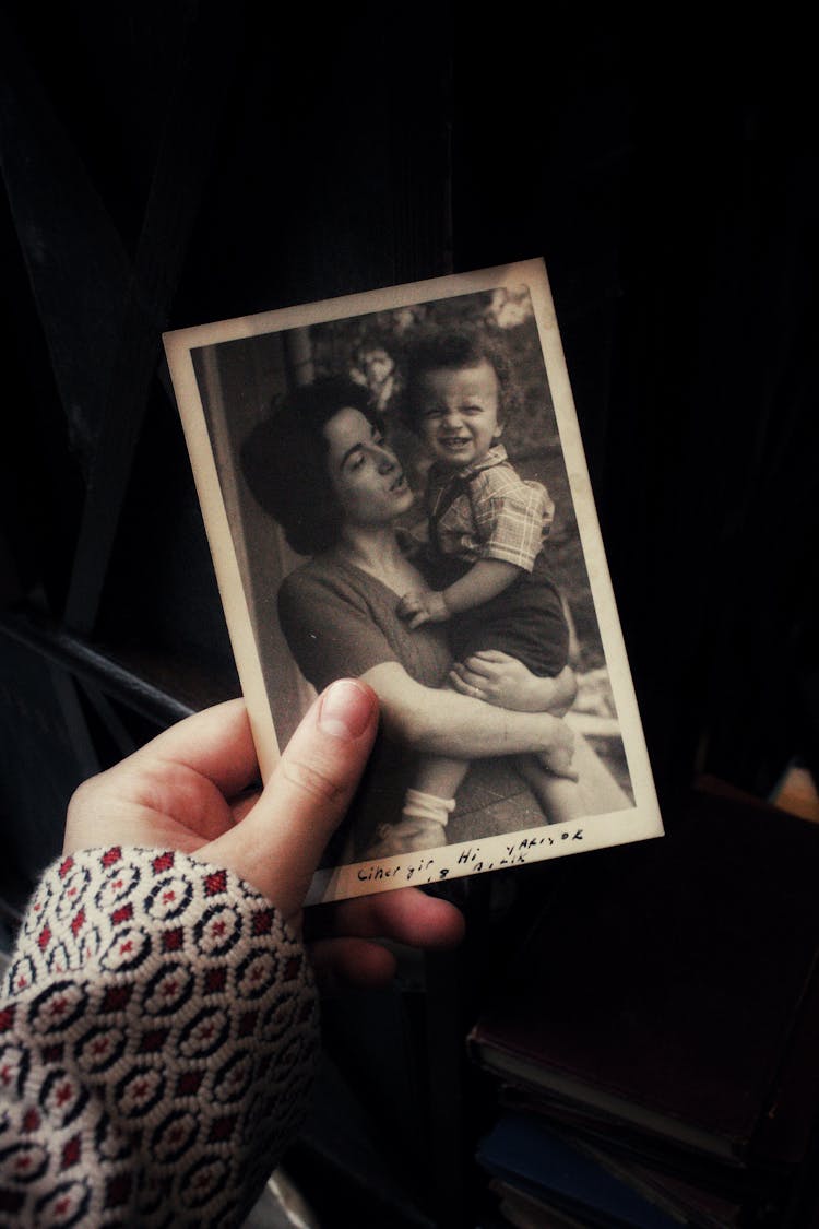 Woman Hand Holding Vintage Photograph Of Mother With Baby