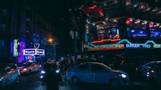 夜晚的城市街道上，霓虹灯闪烁，车流不息，尽显都市生活的繁华