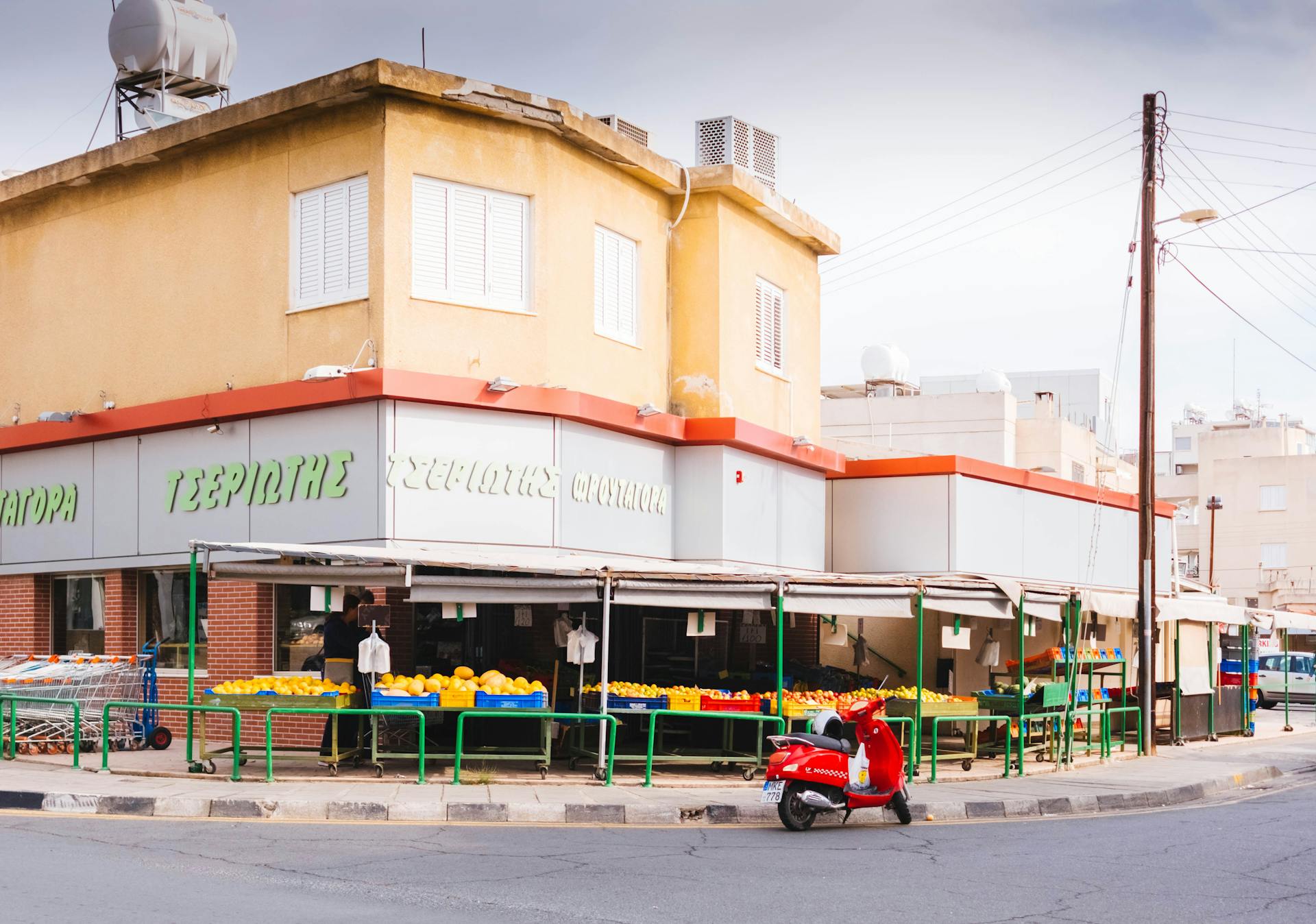 A vibrant street scene featuring a grocery market and a red scooter, ideal for travel or business themes.