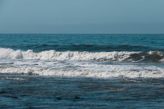Captivating ocean scene with waves breaking under clear blue skies, perfect for seascape enthusiasts.