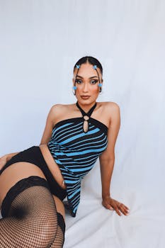 Model posing in trendy striped top with creative hairstyle and accessories.