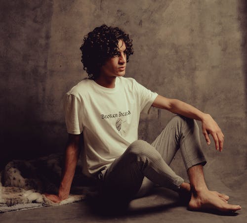 Man with Curly Hair Sitting in Studio