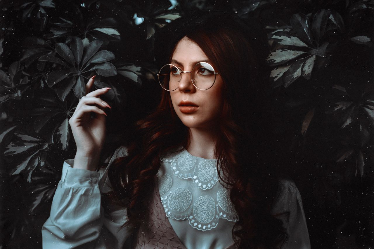 portrait of a woman with eyeglasses in a vintage lace blouse surrounde