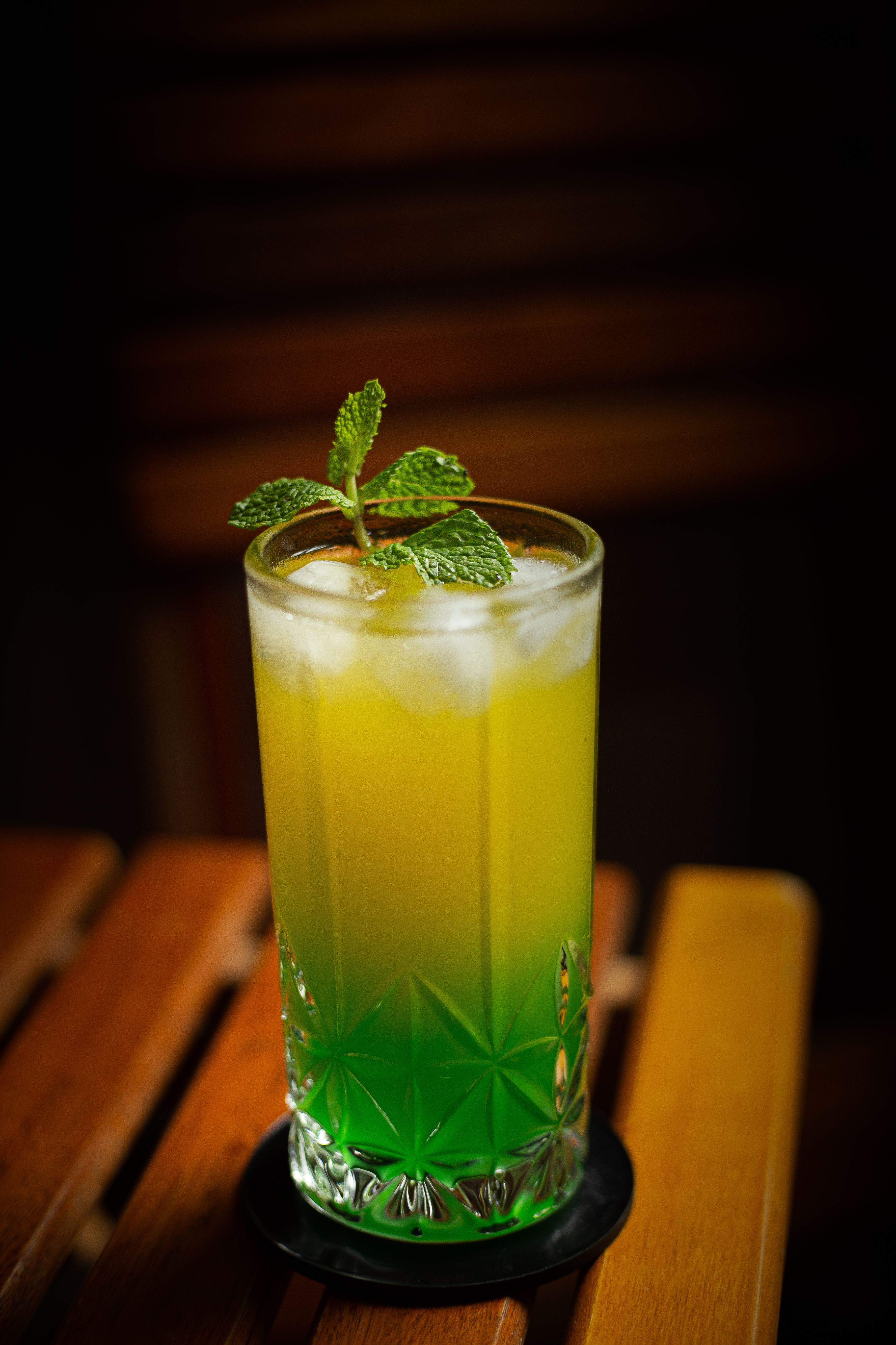A refreshing citrus and mint cocktail in a tall glass with ice and mint garnish.