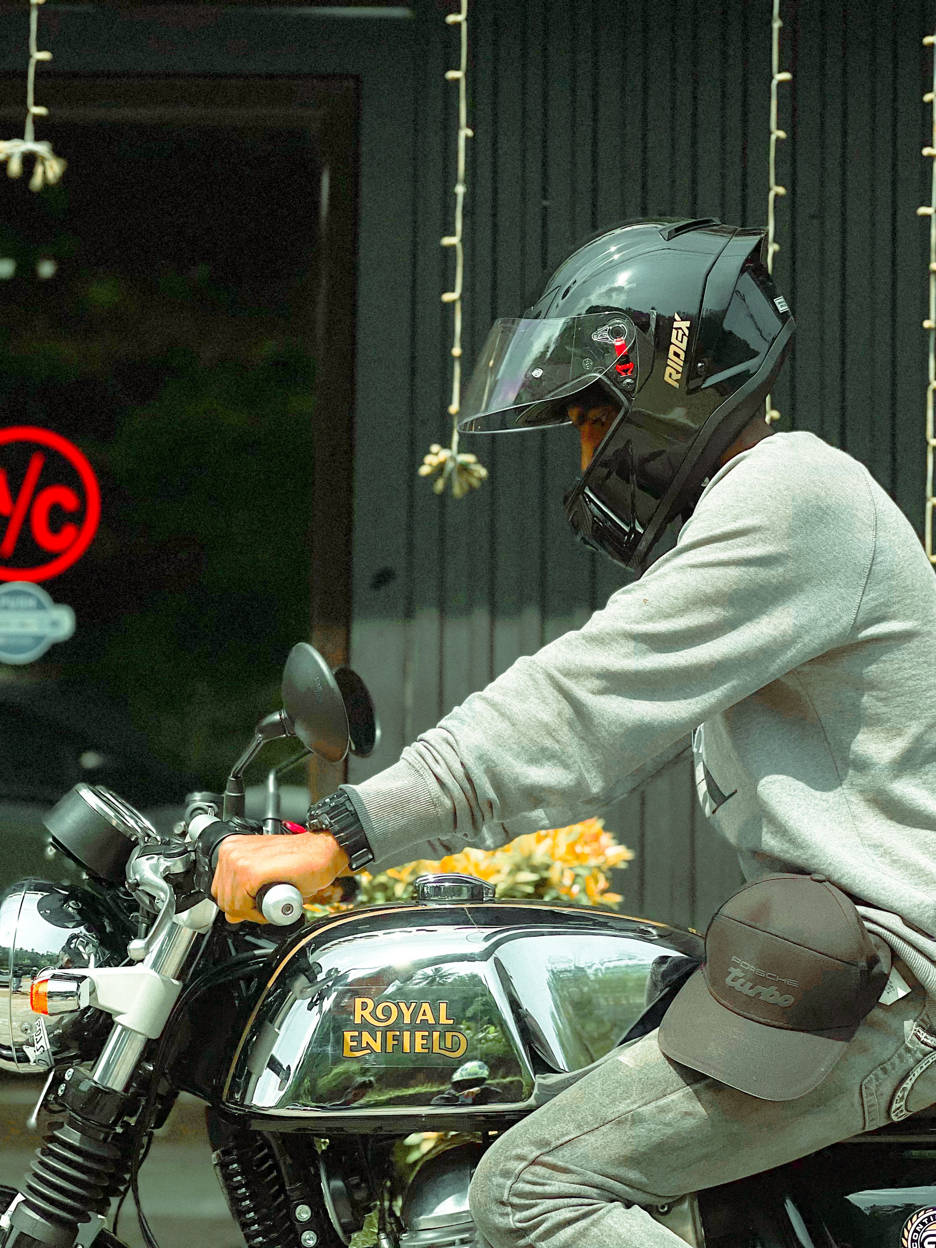 A biker on a Royal Enfield motorcycle wearing a helmet captured in Idukki, India.