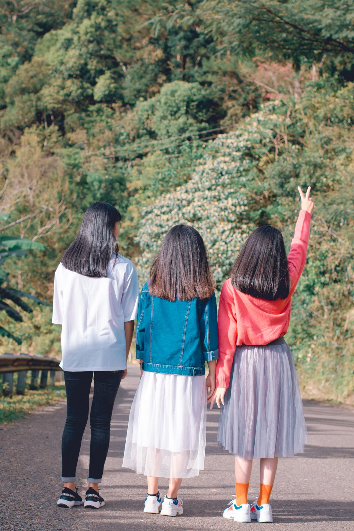 Three friends walking together along a forest path