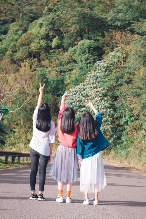 Three Women Standing on Street Near Mountain