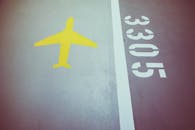 特写：灰色沥青上的黄色飞机符号和白色数字