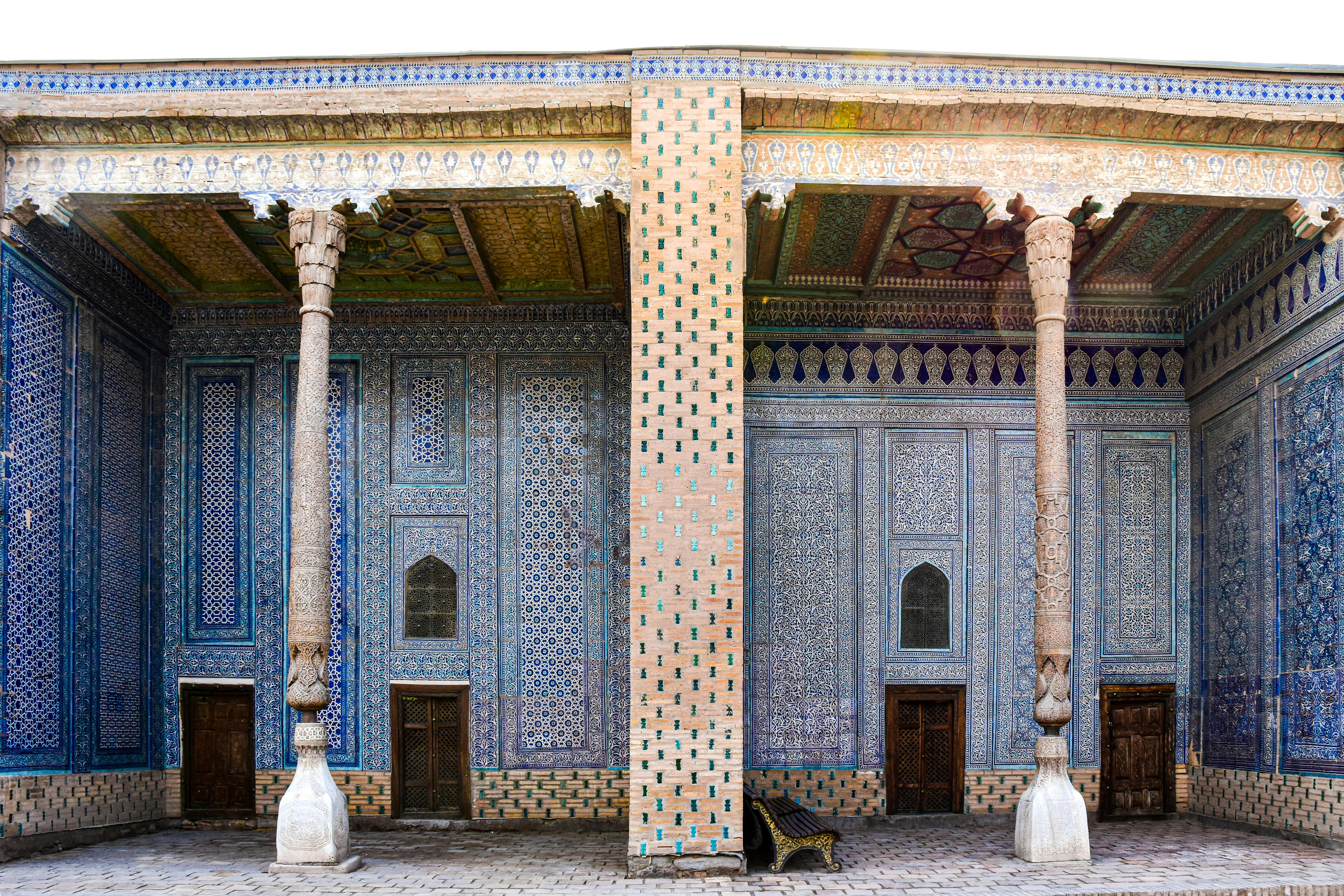 Explore the stunning mosaic architecture in Khiva, Uzbekistan, featuring ornate arches and columns.