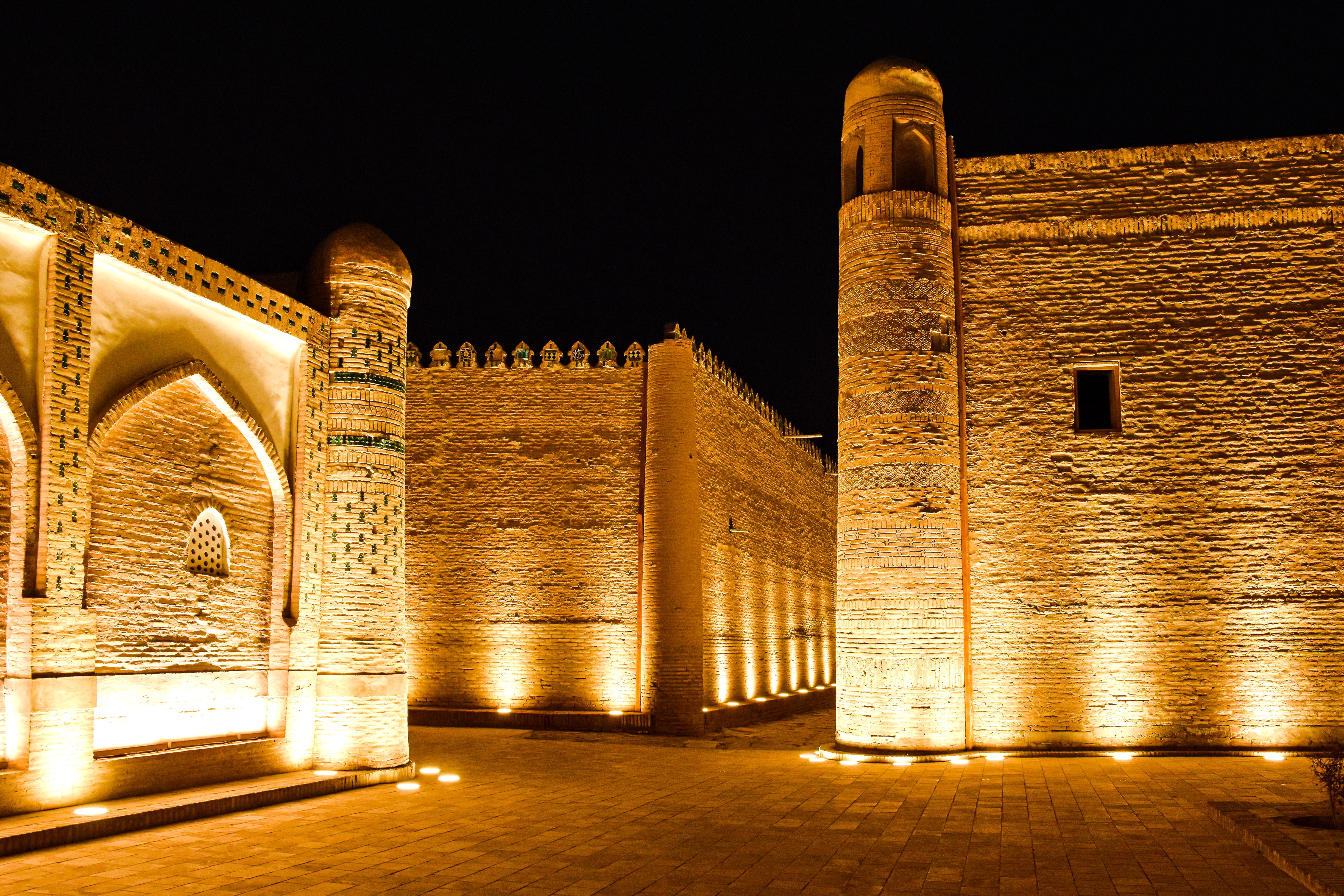 A beautifully lit historic wall in Khiva, Uzbekistan, showcasing Islamic architecture at night.