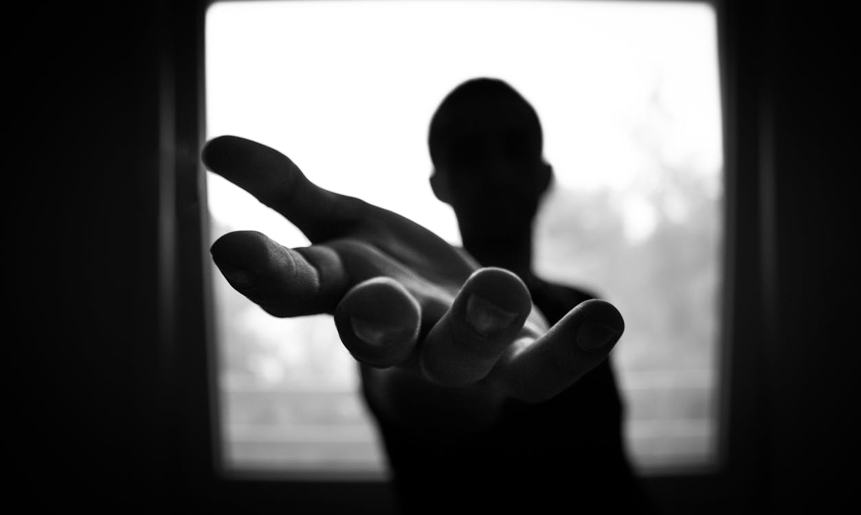 Free Man's Hand in Shallow Focus and Grayscale Photography Stock Photo
