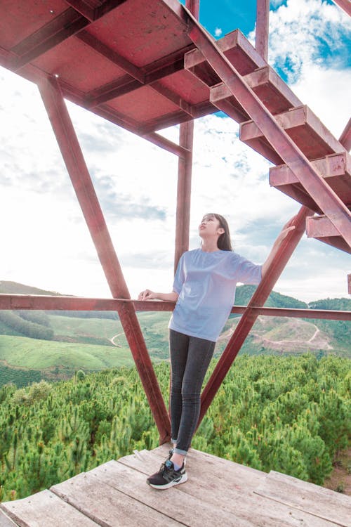 Woman Leaning on Red Steel Frame