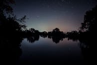 宁静的湖畔，星空映照着平静的水面，营造出宁静的氛围