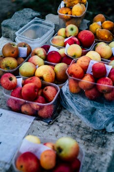 Colorful mix of fresh apples and apricots displayed at an outdoor market, highlighting their natural freshness and appeal.