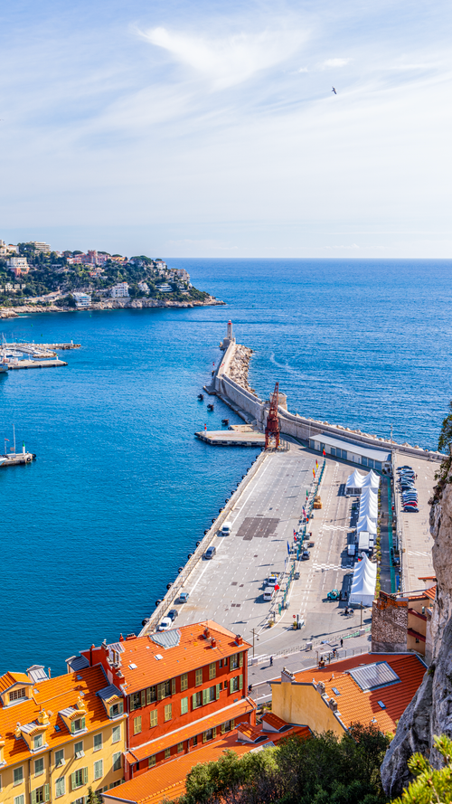 Free A stunning aerial view of Nice harbor in summer, showcasing vivid blue sea and vibrant buildings. Stock Photo