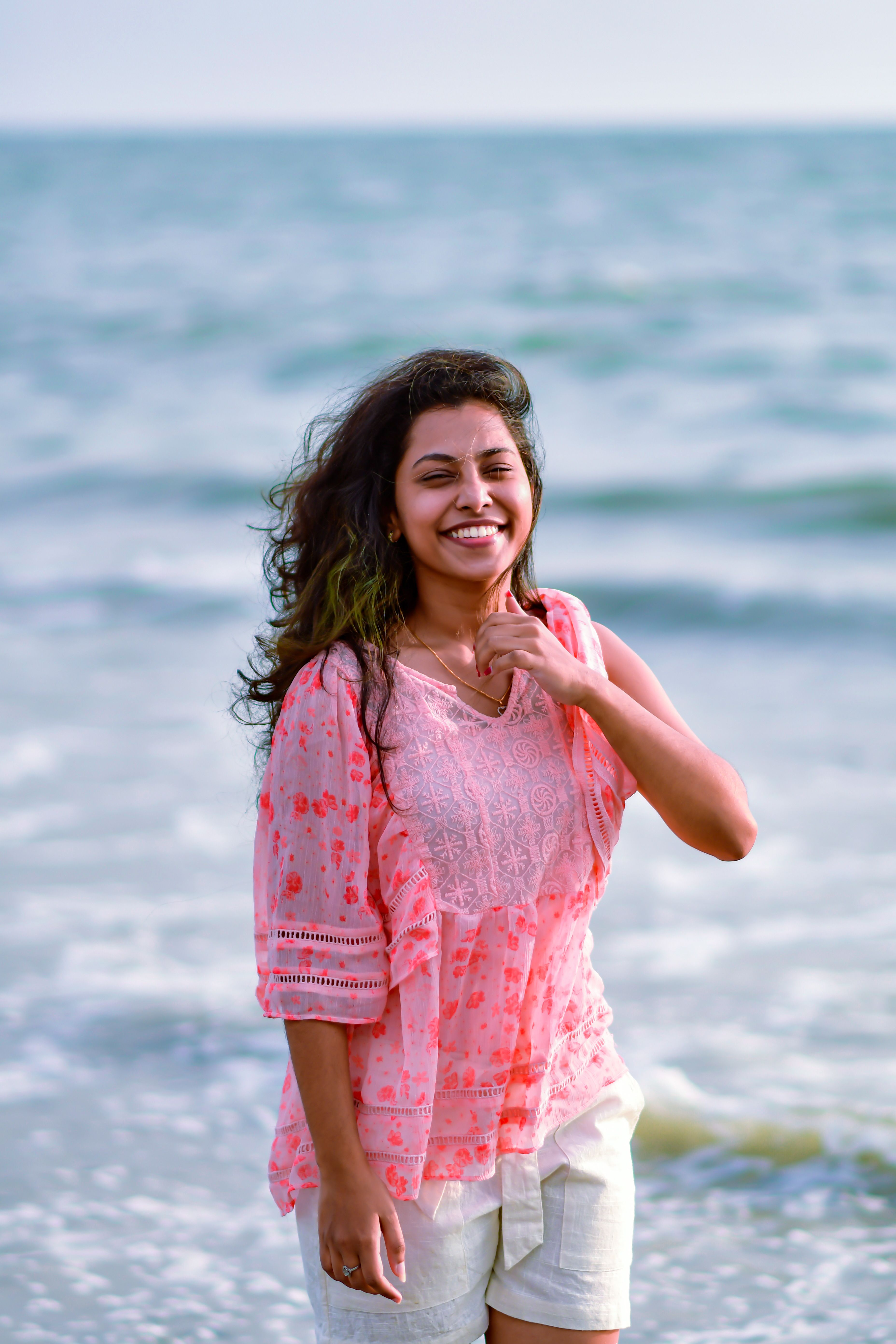Smiling Woman on Sea Shore · Free Stock Photo
