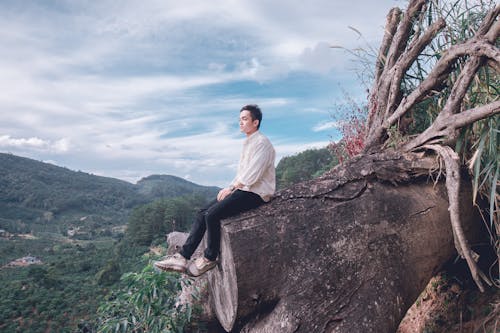 Man Sitting on Tree Trunk