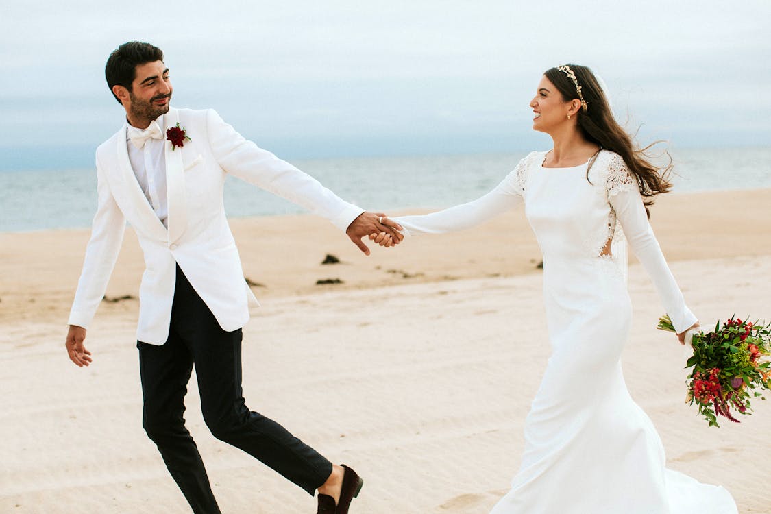 Man Holding Woman's Hand While Walking