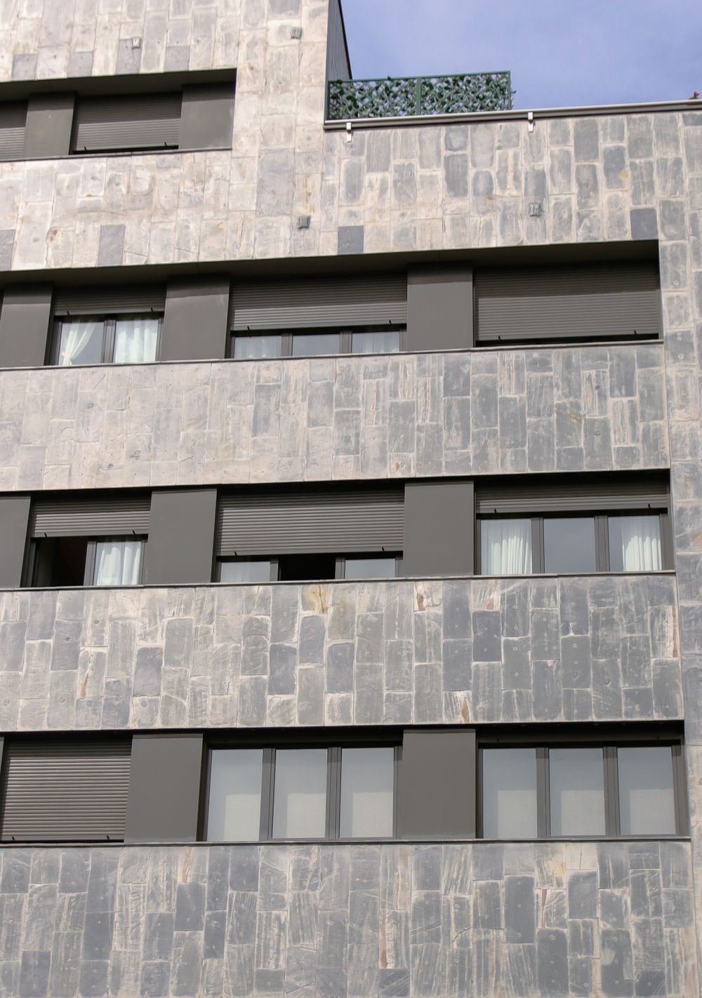 Contemporary building facade finished in pale natural stone panels