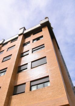Low angle shot of a modern apartment building facade under clear skies in Oviedo, Spain.
