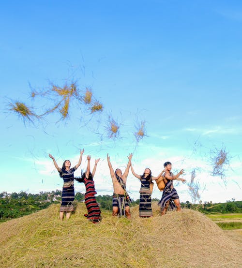 Four People Standing on Hay While Throwing Up