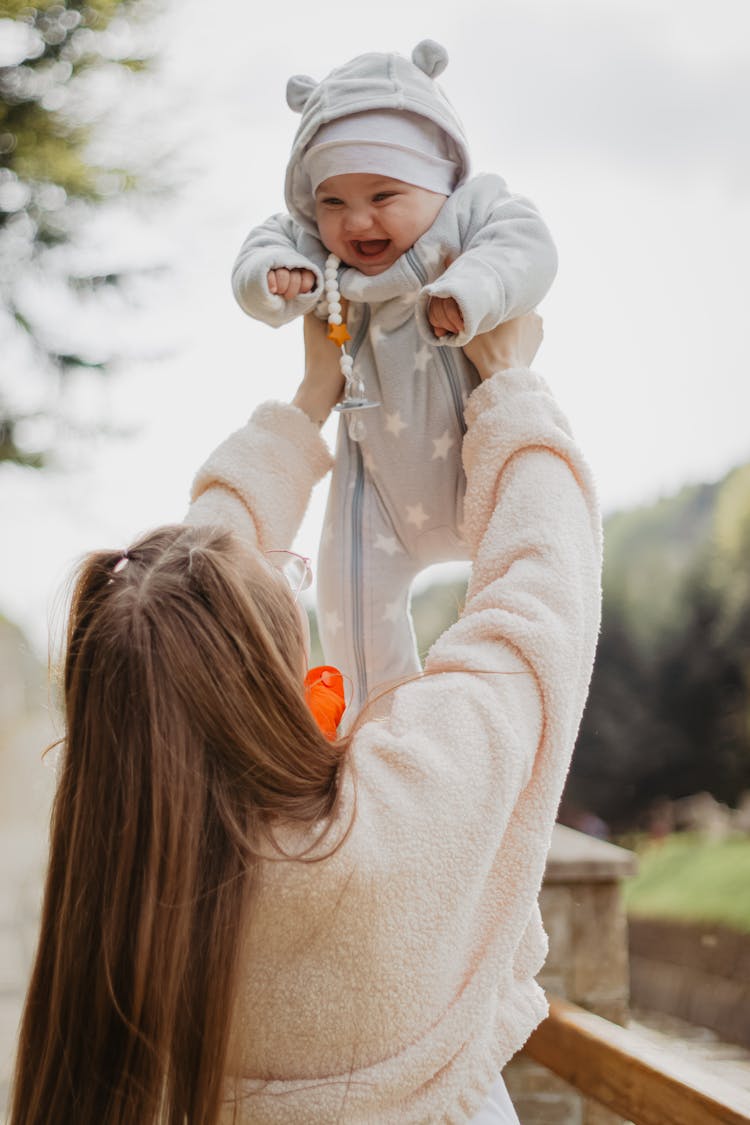 Woman Raising Baby Up