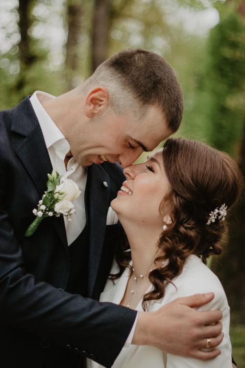 Free A joyful couple embracing at their wedding outdoors, capturing their love and happiness. Stock Photo