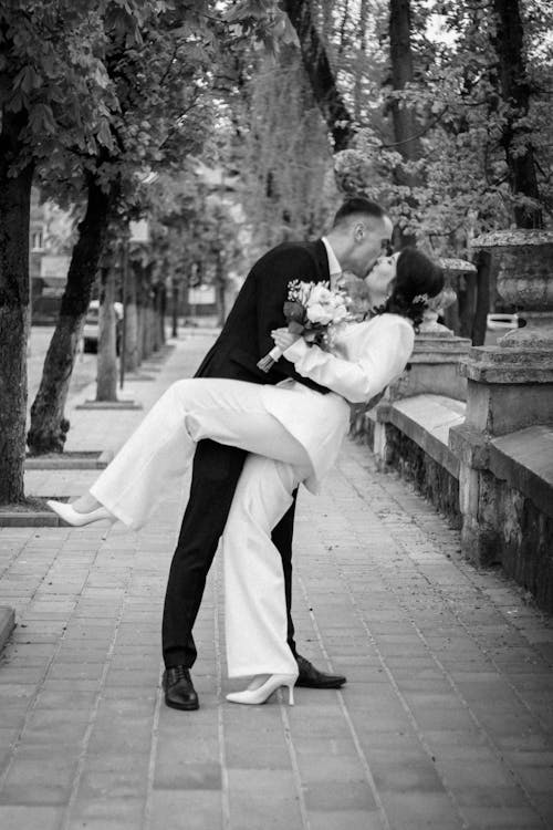 Newlyweds Kissing on a Sidewalk 