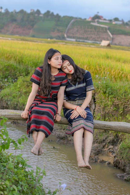 Two Woman Seating on Wooden Footbridge