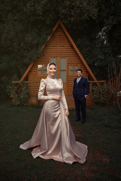 Bride Wearing a Traditional Dress and Hijab and Groom in a Tuxedo 