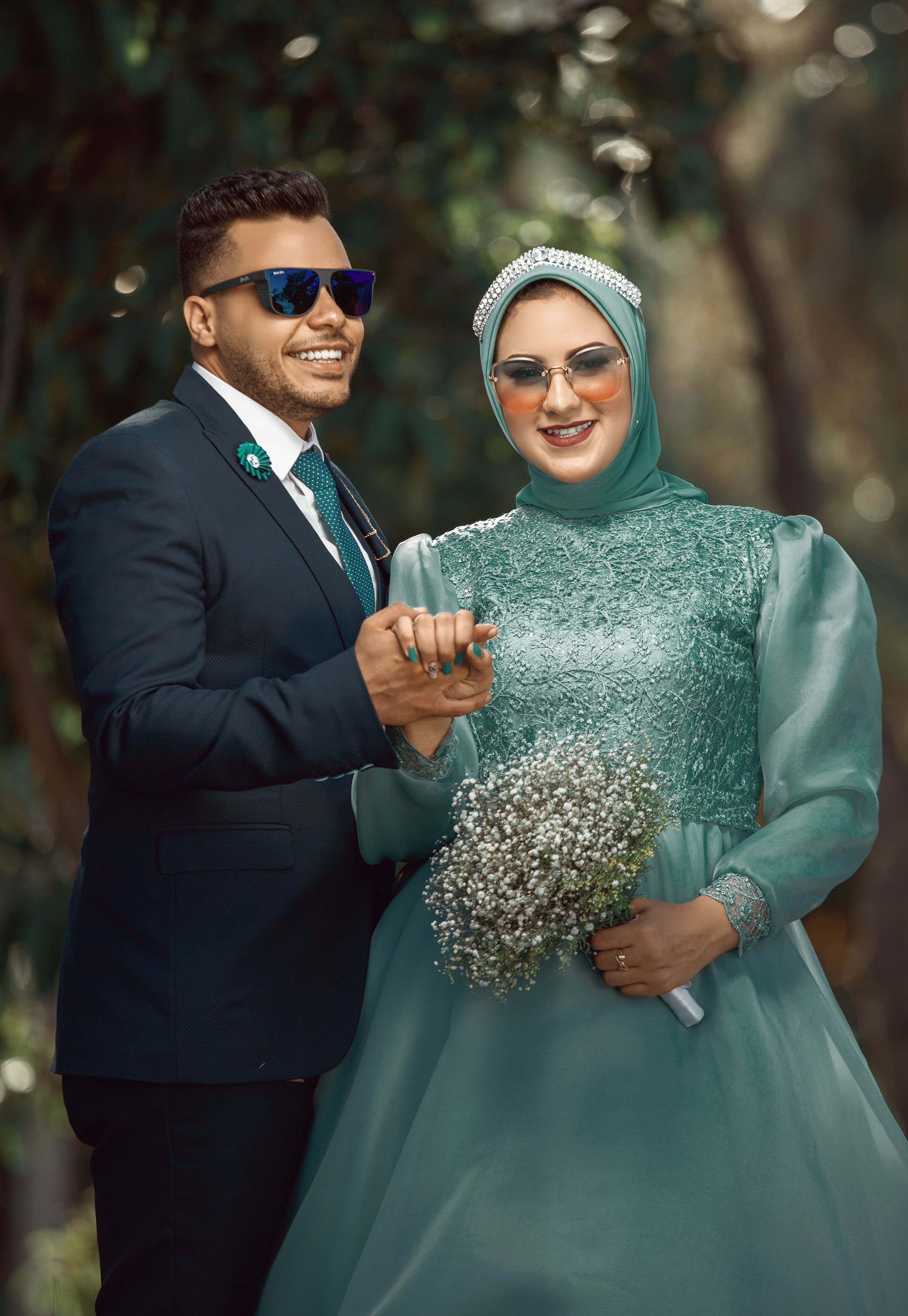 A joyful bride and groom in stylish wedding outfits posing outdoors, exuding elegance and happiness.