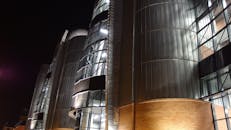 波兰罗兹一座现代建筑的夜景，建筑融入了钢和玻璃元素