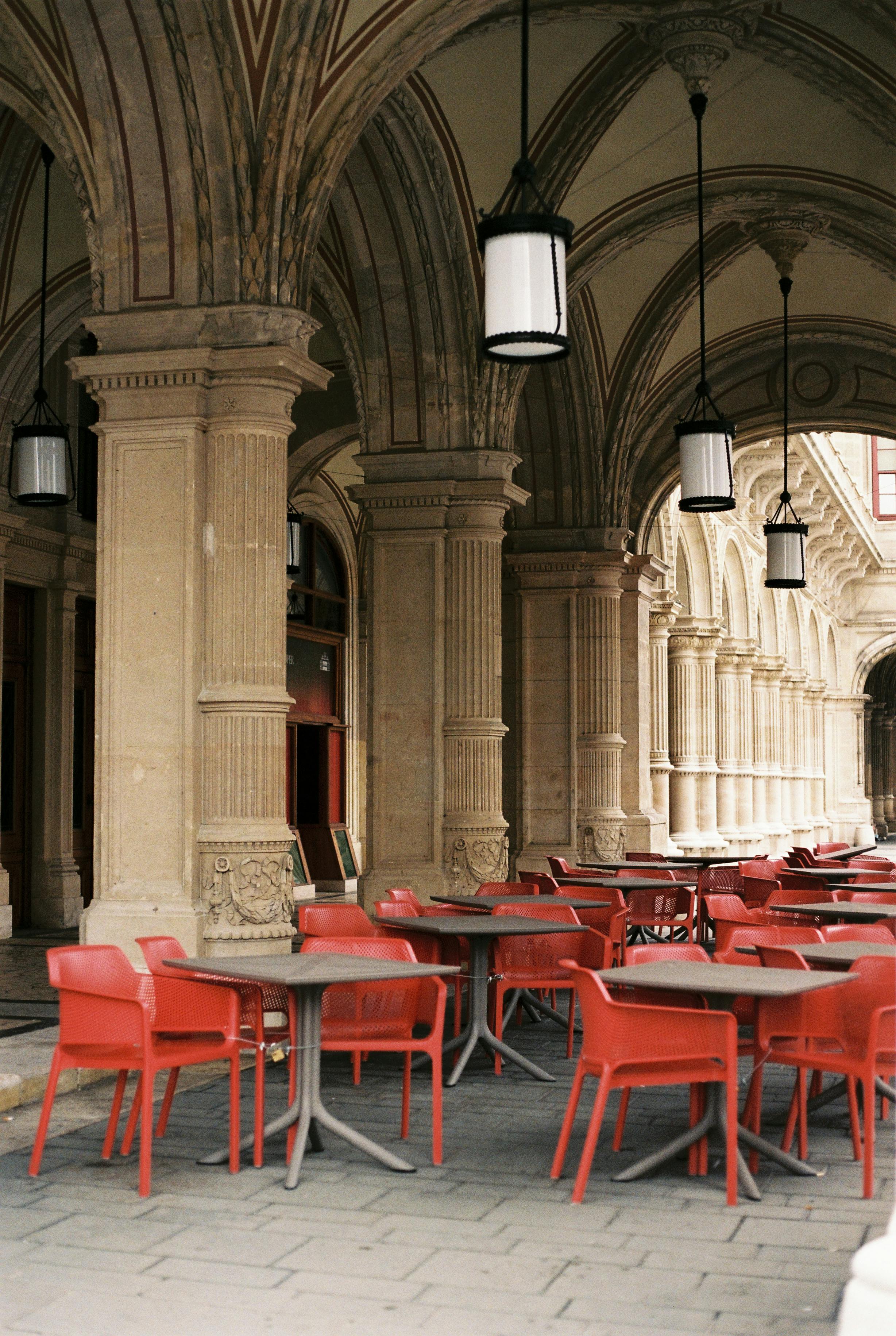 Historic Vienna café with vibrant red seating under ornate arches.
