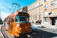 一辆橙色电车行驶在城市街道上，展现了城市公共交通的风貌