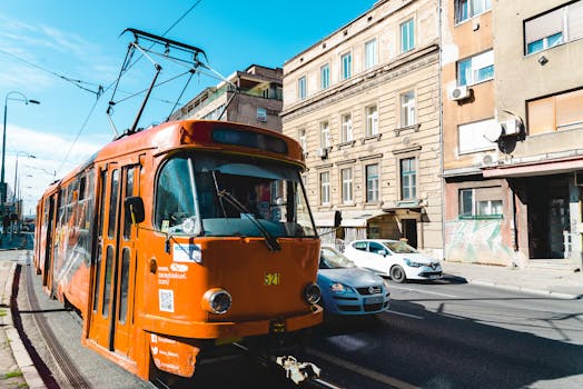 一辆橙色电车行驶在城市街道上，展现了城市公共交通的风貌