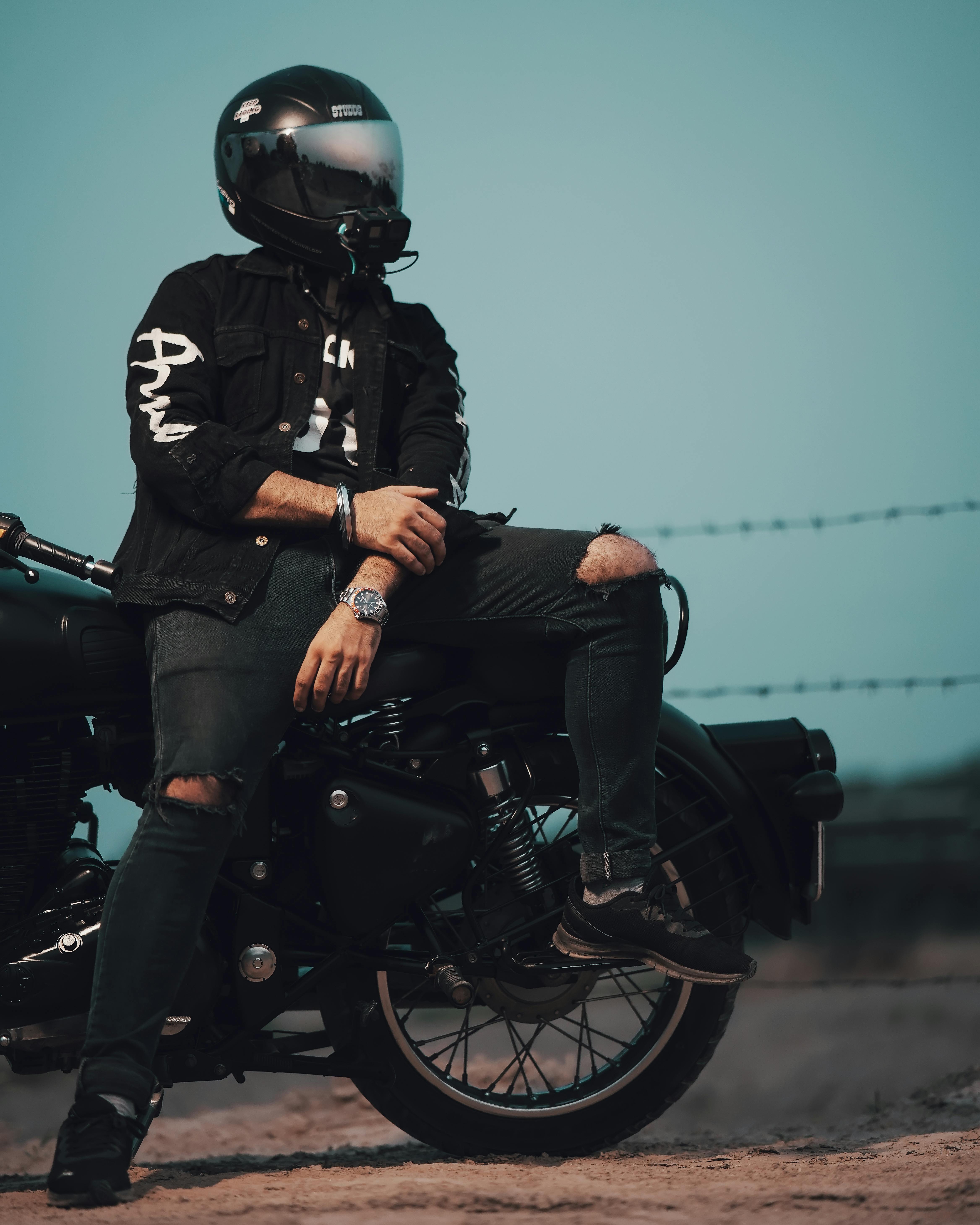 A Man Wearing a Helmet and Ripped Jeans Sitting on a Motorcycle · Free ...