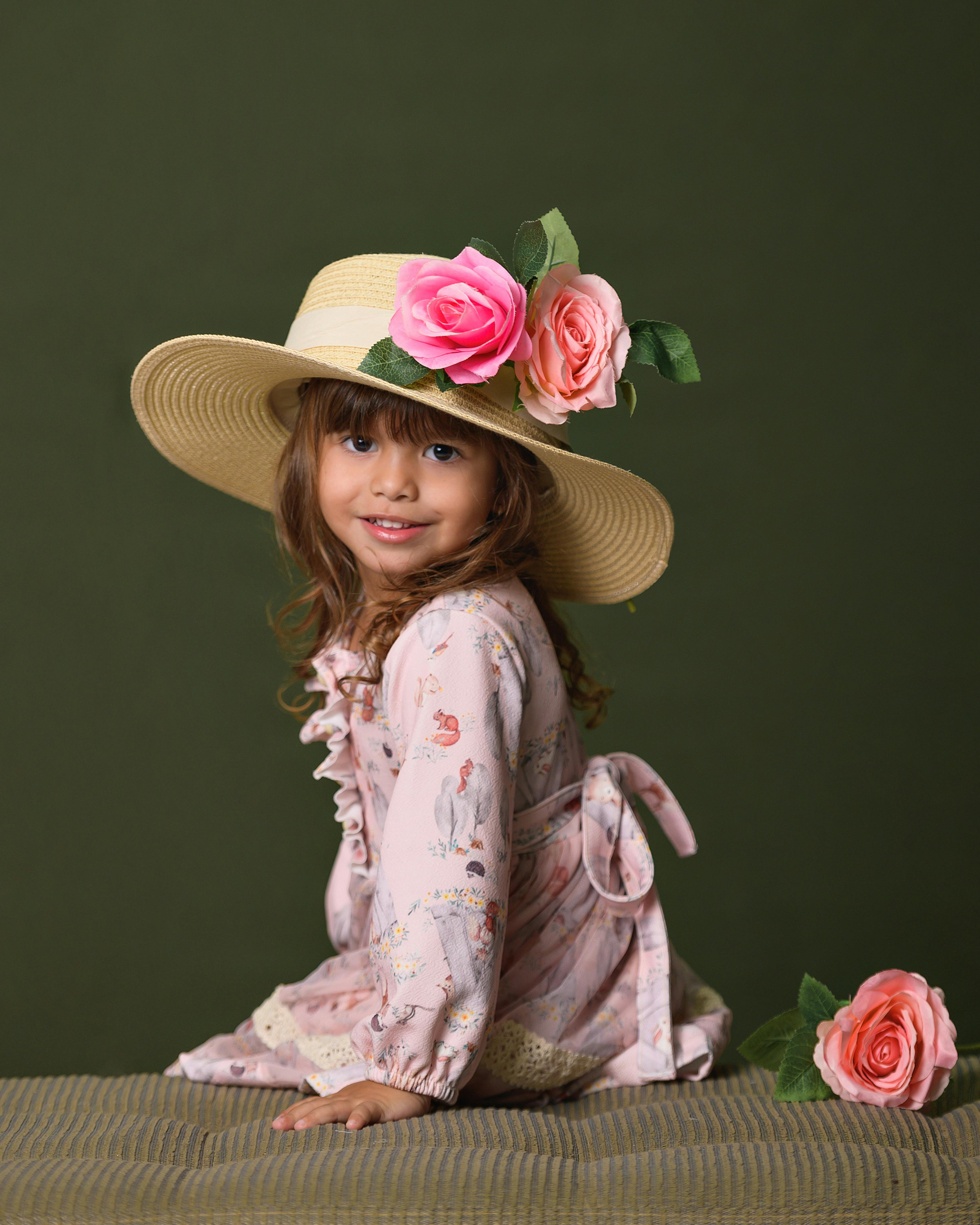 girl in hat with roses sitting and posing