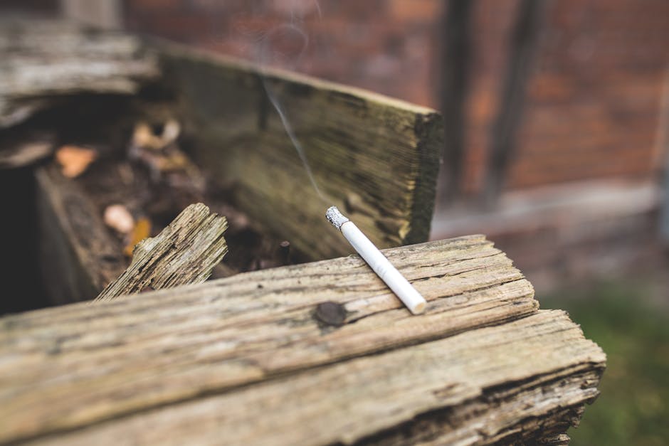 White Lighted Single Cigarette Stick on Beige Wood