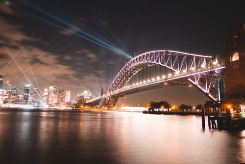 Free Stunning view of illuminated Sydney Harbour Bridge with city skyline and reflections over water at night. Stock Photo