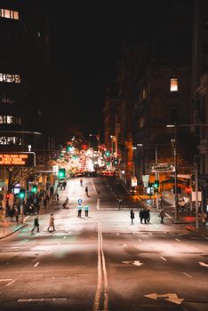 夜晚的城市街道繁忙，灯光闪烁，行人穿梭