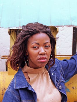 这是一幅年轻女子的肖像，她身着休闲时尚的服饰，在户外展现了自然之美与个人风格