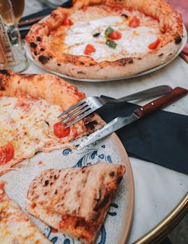 Delicious cheesy pizzas with tomatoes served at a Lyon restaurant.