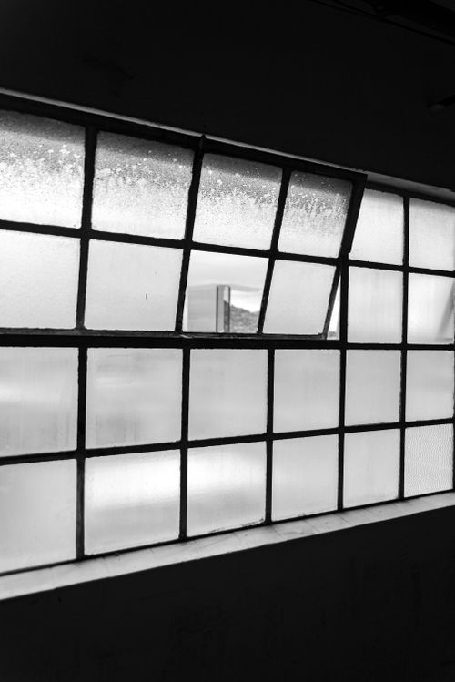 Free A moody black and white photo showcasing a frosted window indoors, casting shadows. Stock Photo