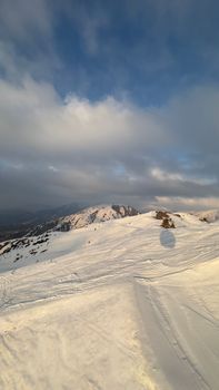 Scenic winter view of snowy mountains and a cloudy sky, showcasing a tranquil winter scene.