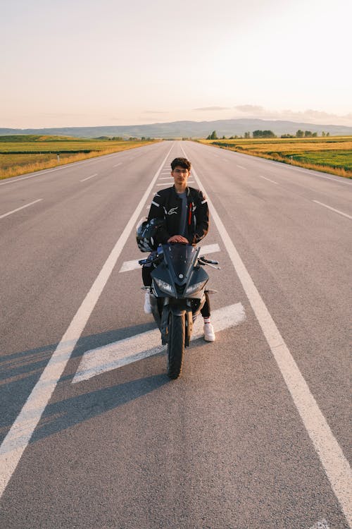 Free A Young Man on a Motorcycle in the Middle of a Road  Stock Photo